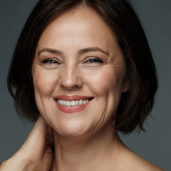 woman with dark brown bob and light makeup smiling