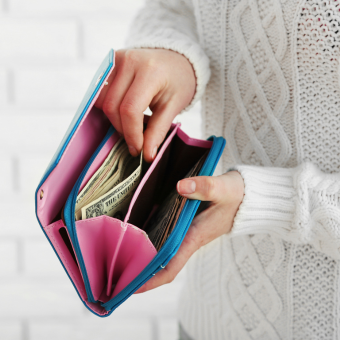 Person reaching for money from a multicolored wallet