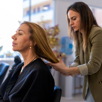 Hairdresser examines client's hair